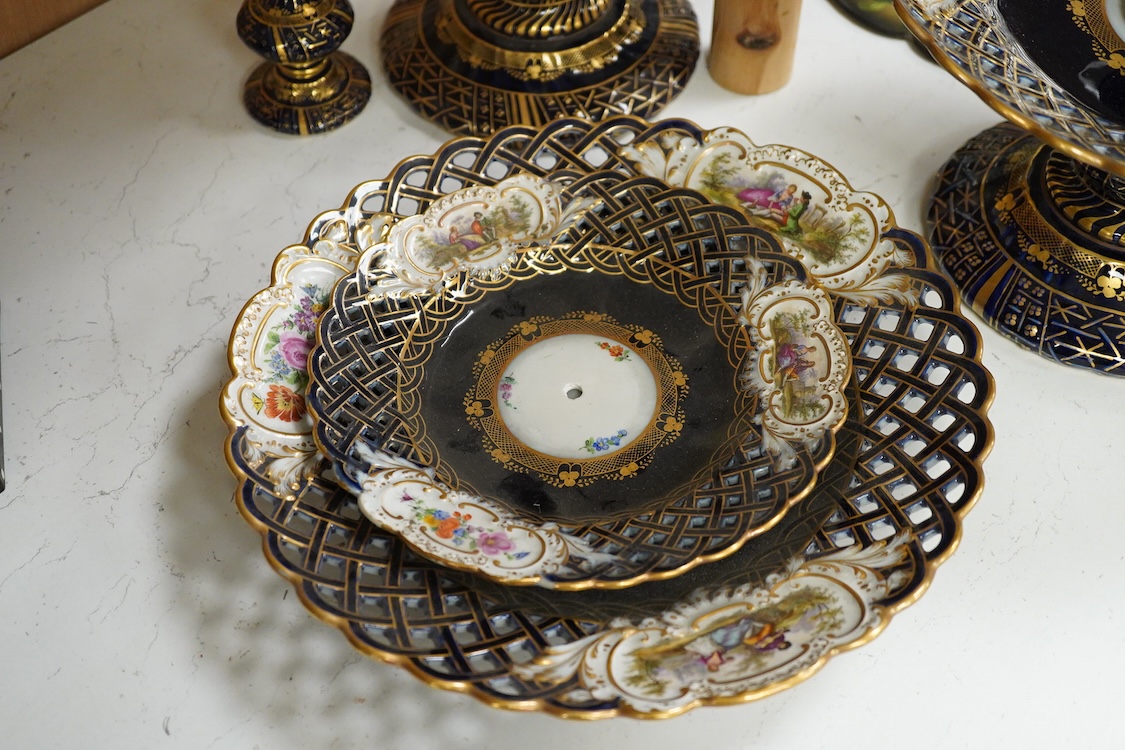 A pair of late 19th century Meissen three tier cake stands with figural tops, 48cm high